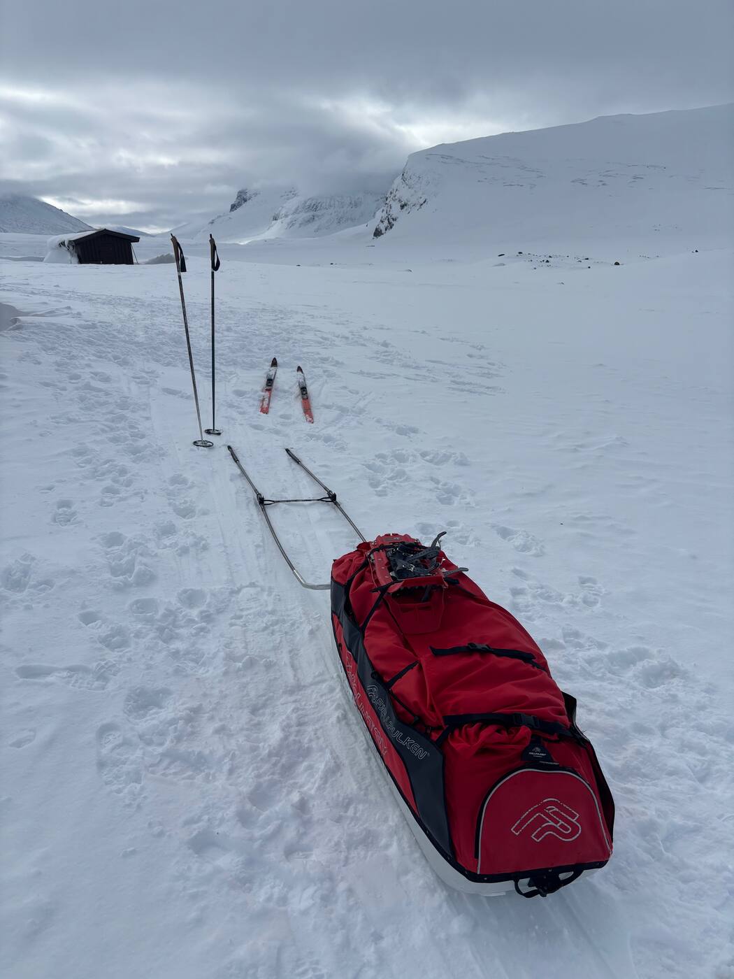 Pulka Fjellpulken rouge devant une cabane STF, Laponie suédoise